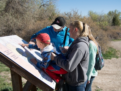 POCATELLO, Idaho — James Bransford, left, Rebecca Bransford, right, and Dennis Turner, back center, take a look at the hiking trail map to determine which route to take at the City Creek trail head on Tuesday April 28, 2015. (Photo by Missy M Turner)